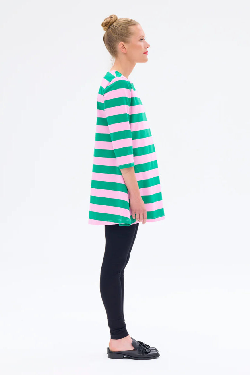 Woman wearing a green and pink striped dress on a white background