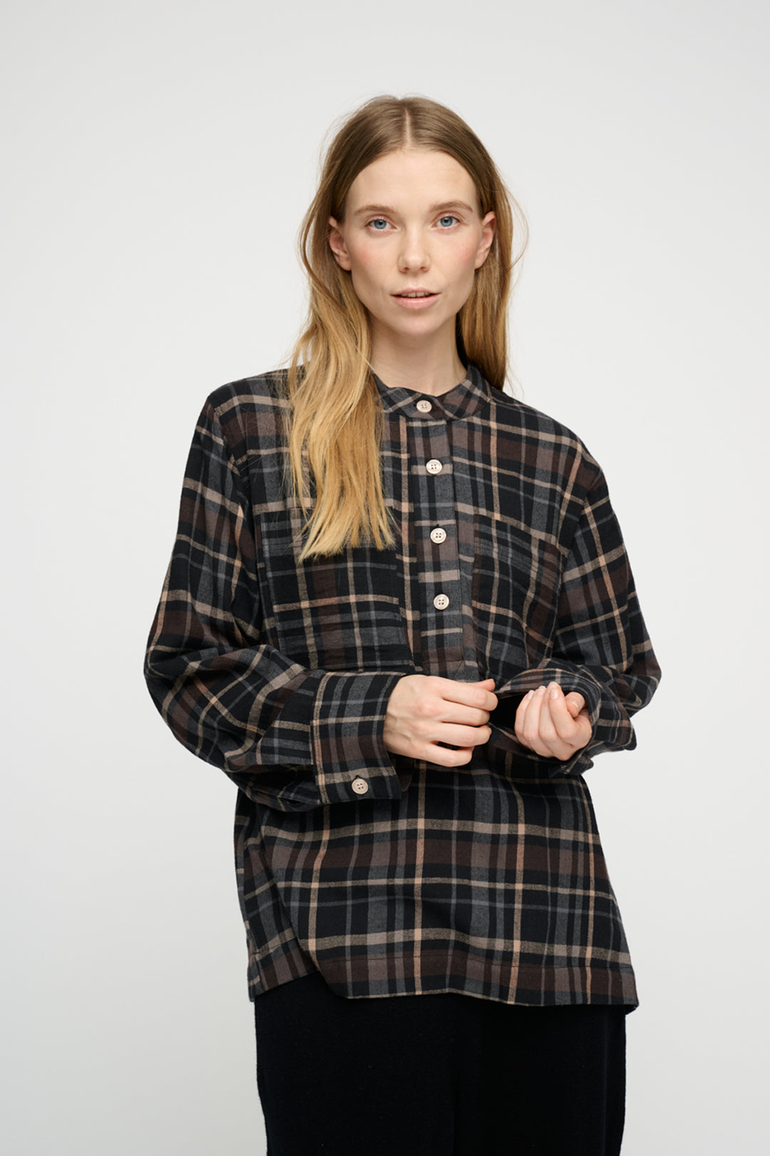 Woman wearing a plaid shirt against a white background