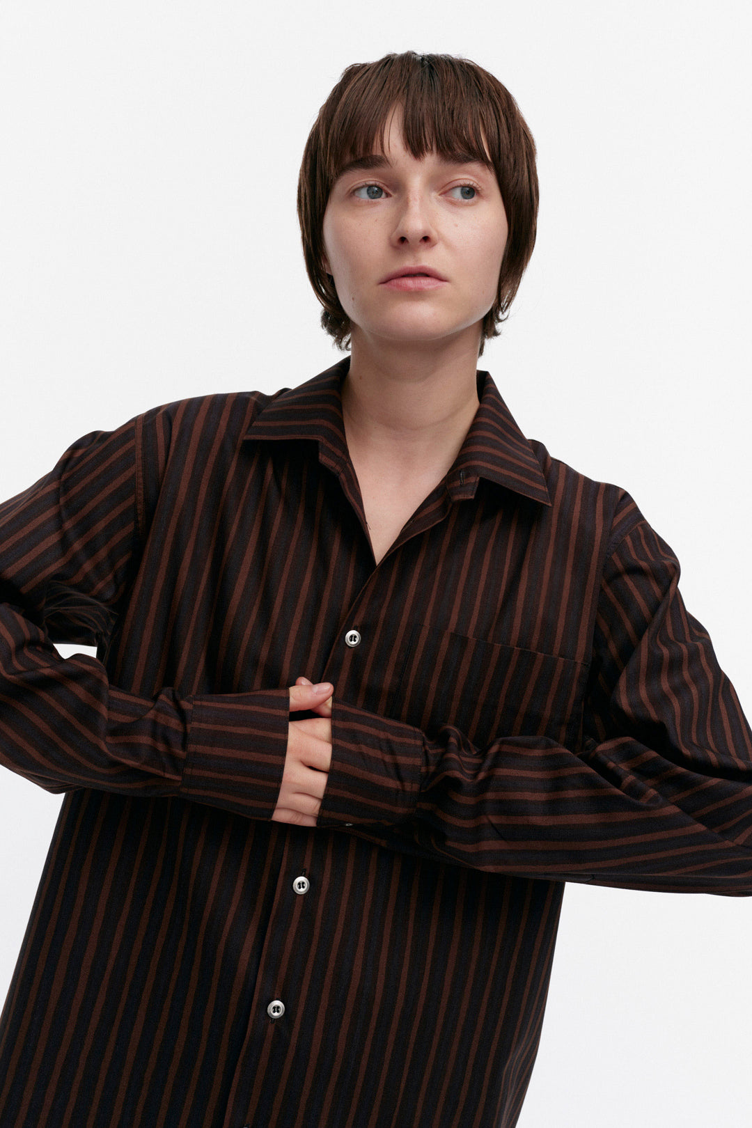 Person wearing a brown striped shirt on a white background