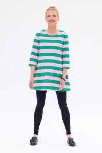 Woman wearing a green and pink striped dress on a white background