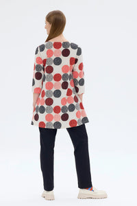 Woman wearing a long, patterned cardigan with red and black dots on a white background