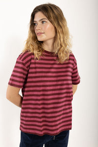Woman wearing a red and pink striped t-shirt against a white background
