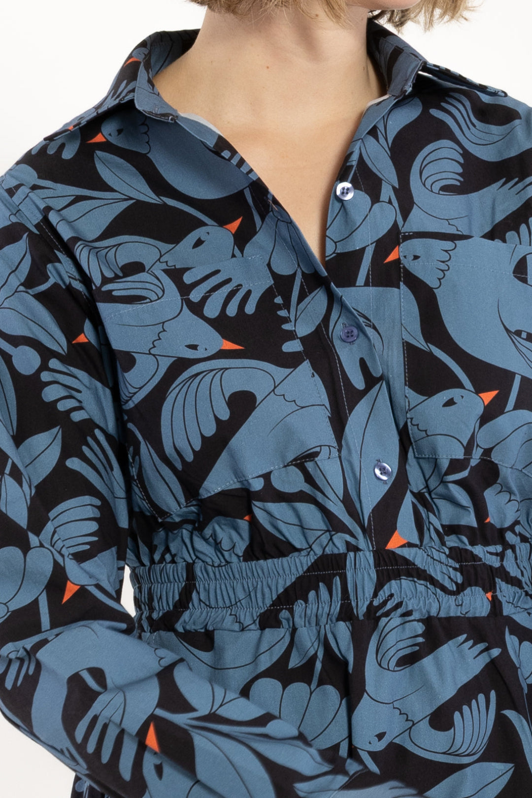 Close-up of a person wearing a patterned dress with blue and black design.