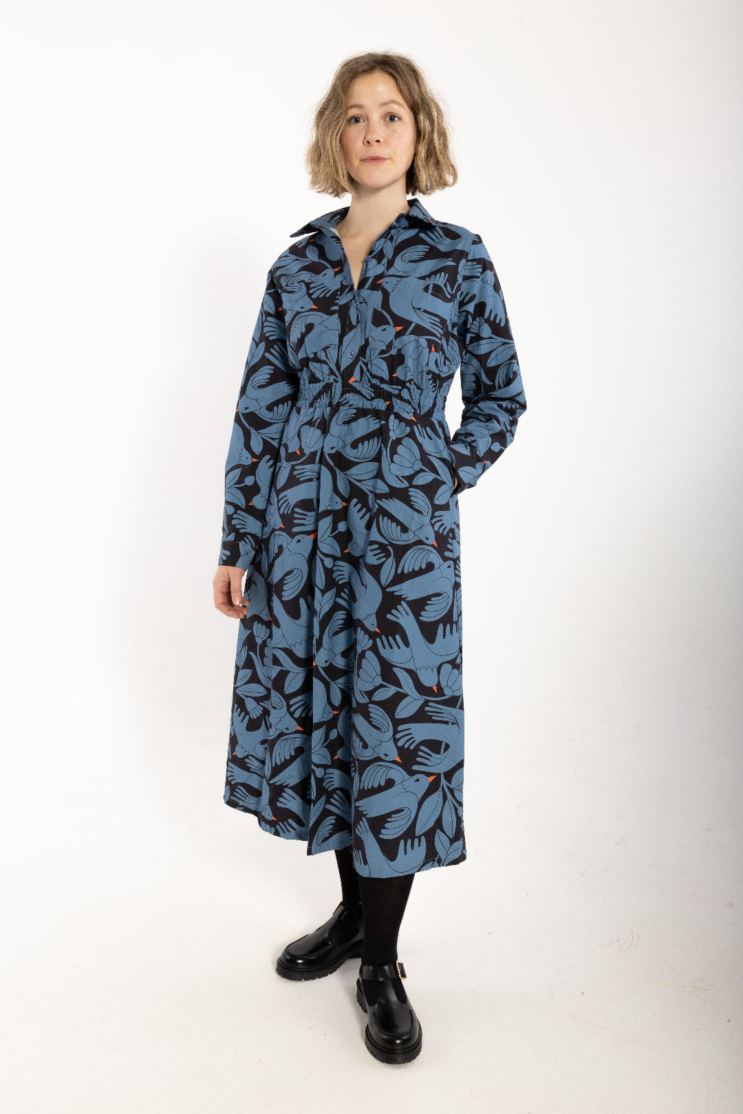 Woman wearing a blue patterned dress on a white background