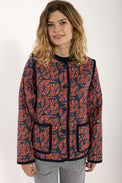 Woman wearing a red and blue patterned jacket on a white background
