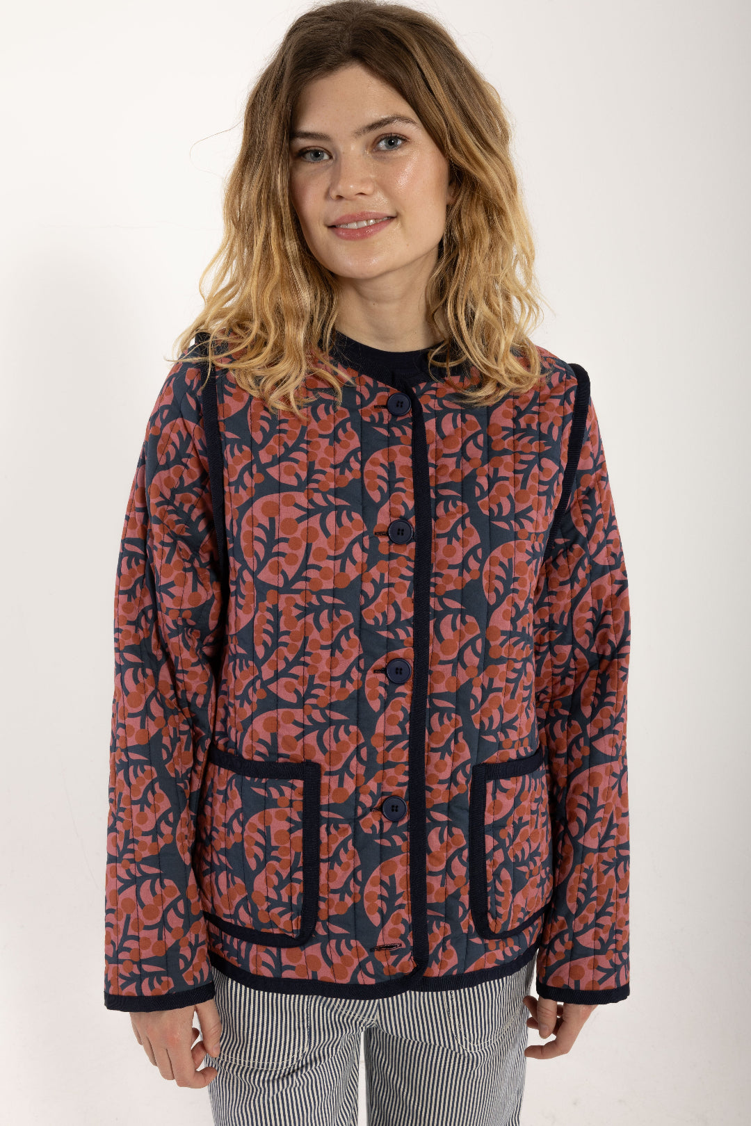 Woman wearing a red and blue patterned jacket on a white background