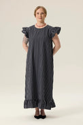 Woman wearing a black and white striped dress on a plain background