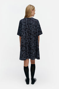 Woman wearing a black patterned dress on a white background