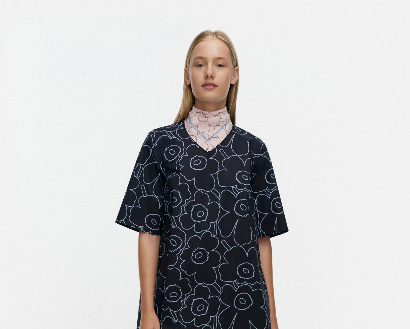 Woman wearing a navy floral patterned dress and bandana on a white background