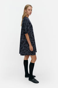 Woman wearing a blue patterned dress on a white background