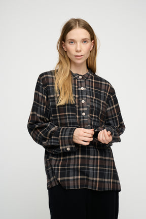 Woman wearing a plaid shirt against a white background
