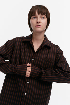 Person wearing a brown striped shirt on a white background