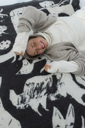 Person lying on a black and white patterned blanket