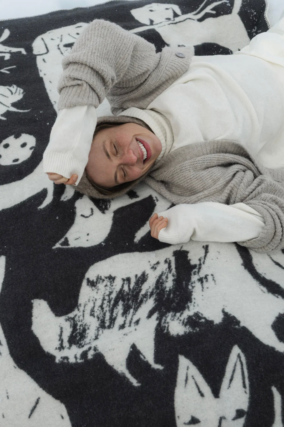 Person lying on a black and white patterned blanket