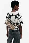 Person wearing a black and white patterned shirt with a Marimekko bag.